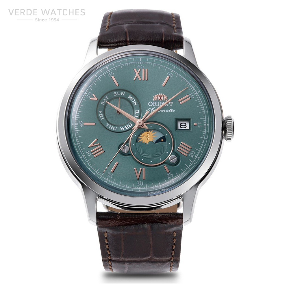 Orient automatic wristwatch with teal dial, rose-gold indices, day and date subdial, moon phase display, and brown leather strap.